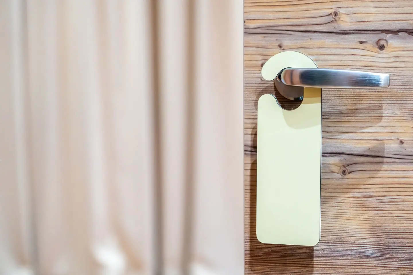 El tirador de la puerta de una habitación de hotel, con el colgador puesto.